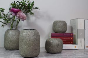 Gruppenbild graue Vasen mit rosa Blumen und Büchern